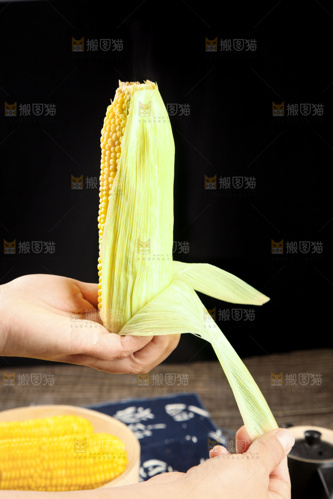 手里拿着新鲜玉米