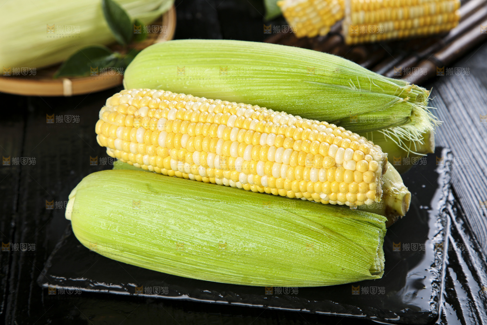 黑石板上放着水果玉米