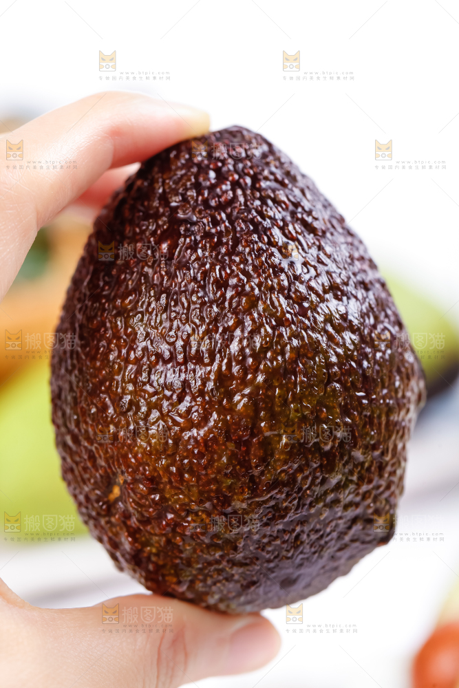 手里拿着新鲜牛油果