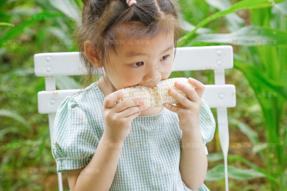 小女孩正在吃牛奶水果玉米