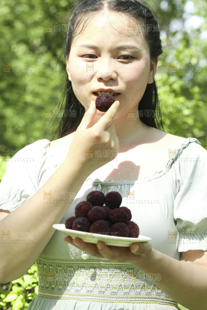 手里端着一盘新鲜杨梅