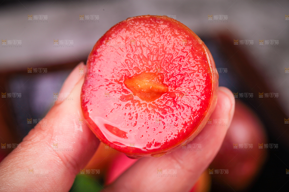 手里拿着红心李子