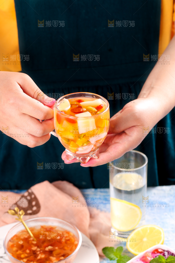 手里拿着一杯水果凉粉