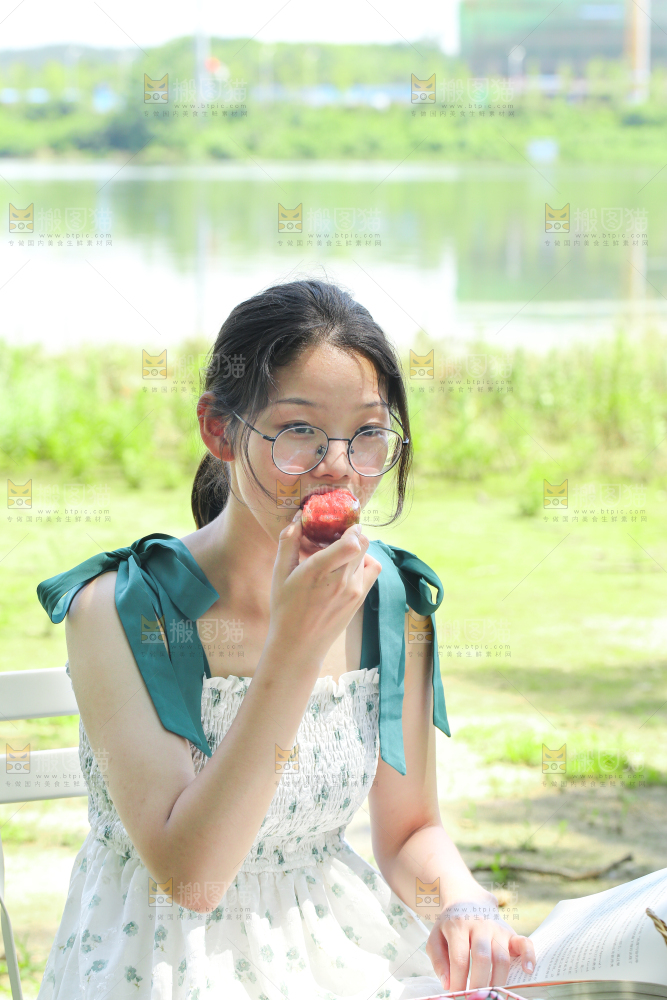 女孩正在吃红肉李子
