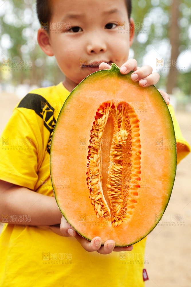 小男孩手里拿着哈密瓜