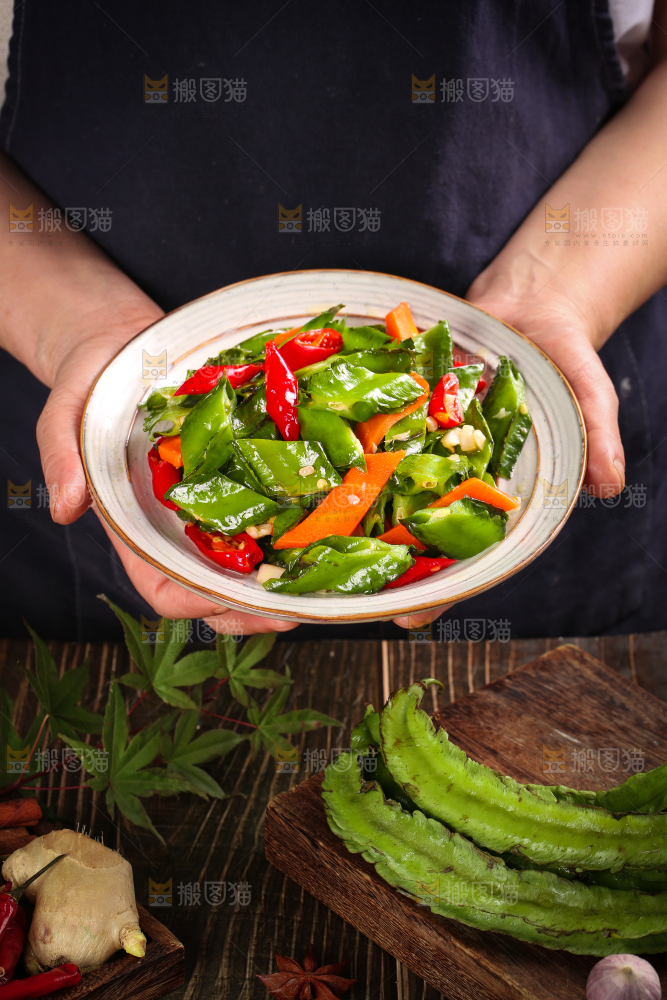 手里拿着一盘炒四角豆