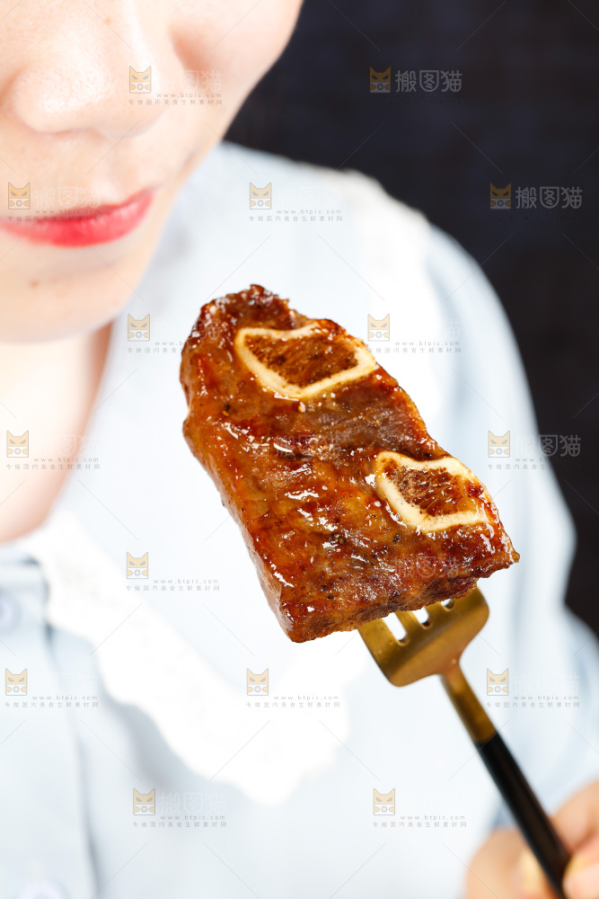 叉子叉着一块煎牛肋骨