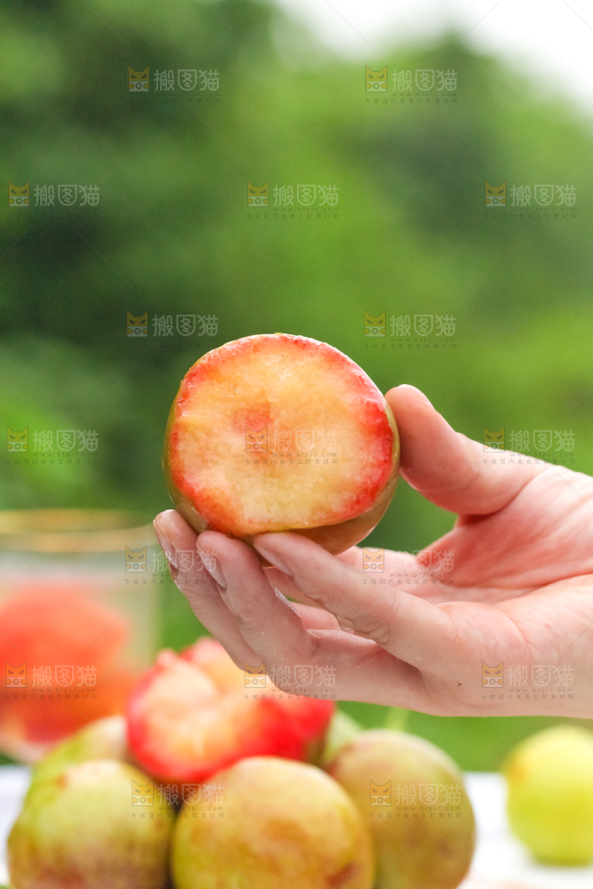 手里拿着新鲜青皮红心李