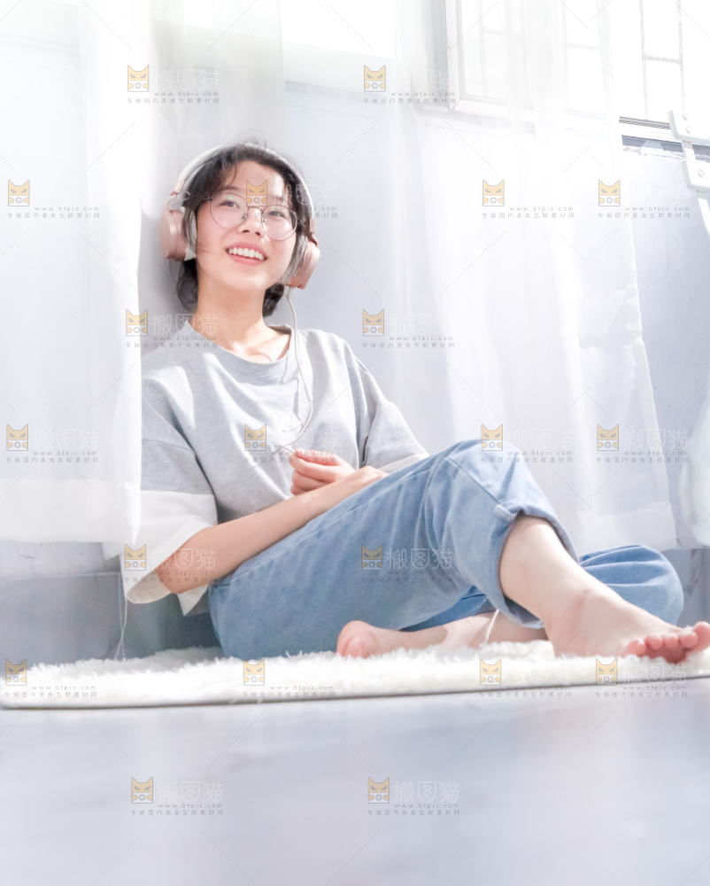毛毯上坐着一位带耳机的女孩