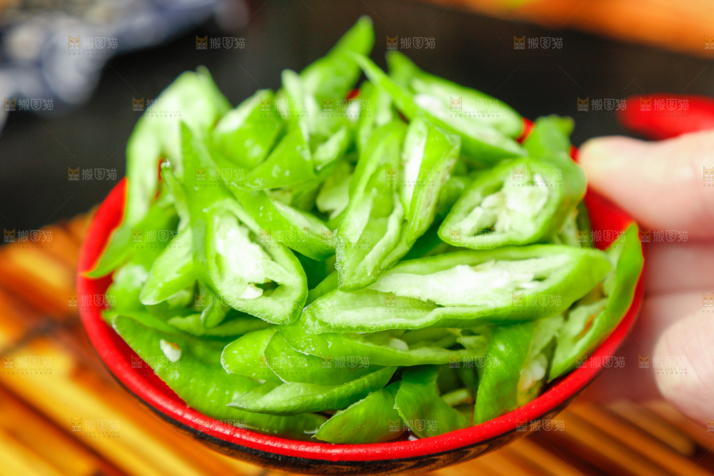 手里拿着一盘切好的杭椒