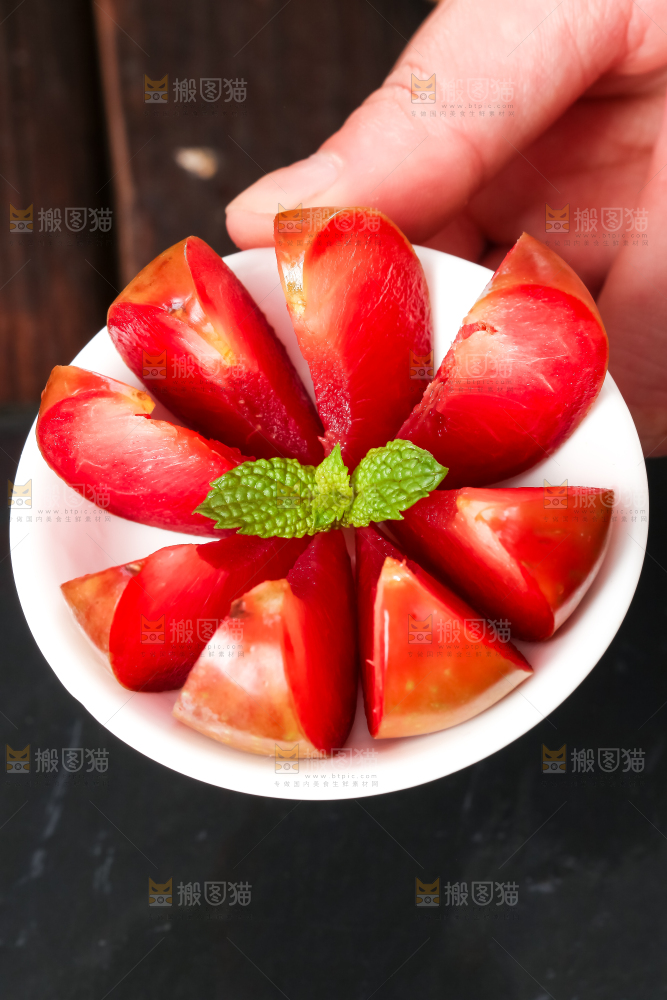 手里拿着一盘红心李子