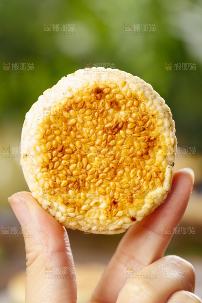 手里拿着手工芝麻饼