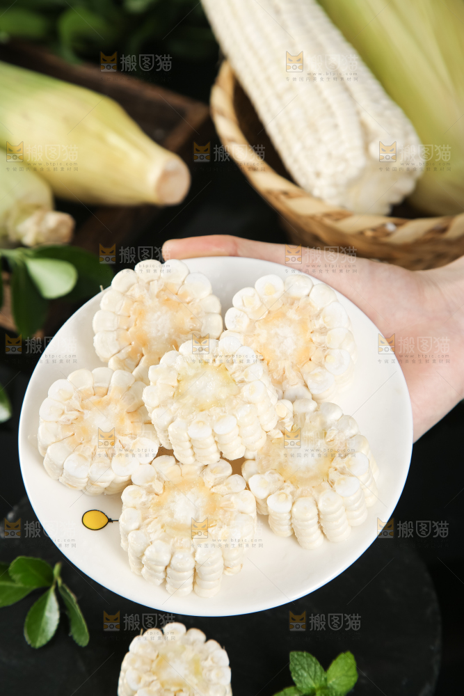 手里端着一盘玉米