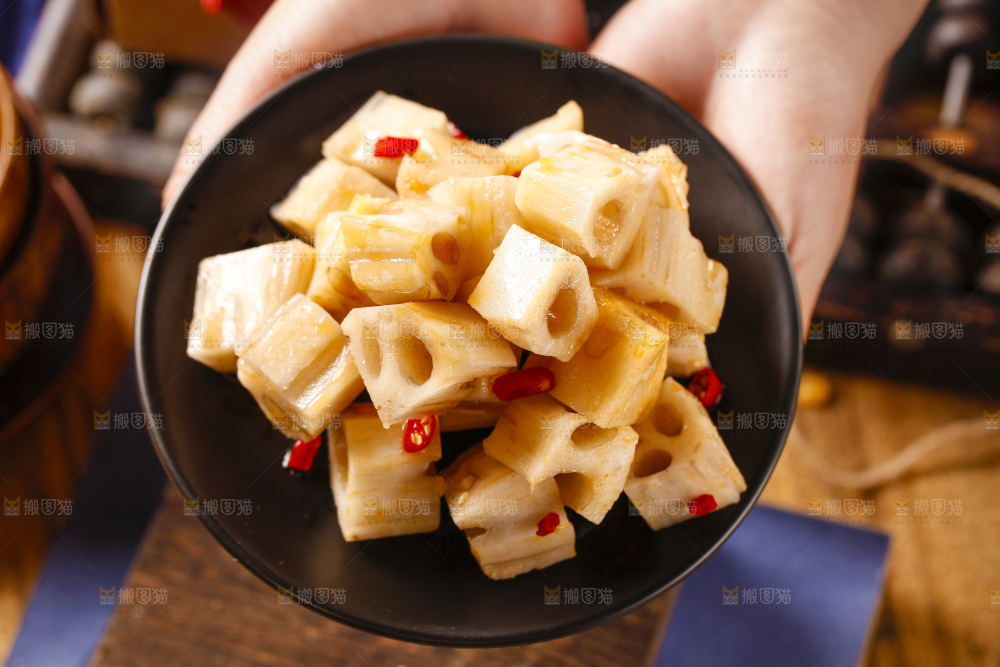 手里拿着一碟香辣藕丁