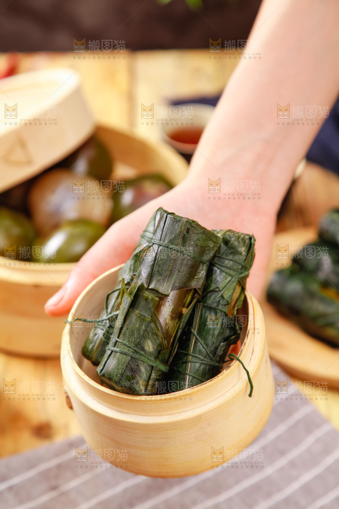 手里拿着竹筒肉粽