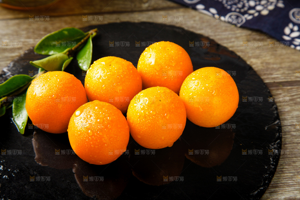 黑石板上放着新鲜金桔
