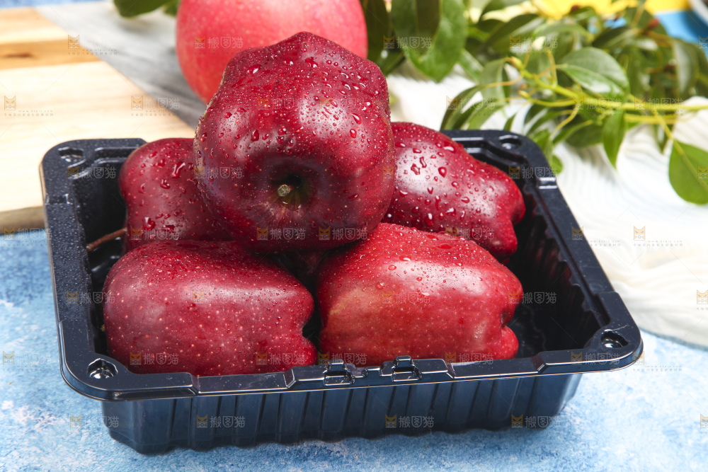 蓝底上放着一盒花牛苹果