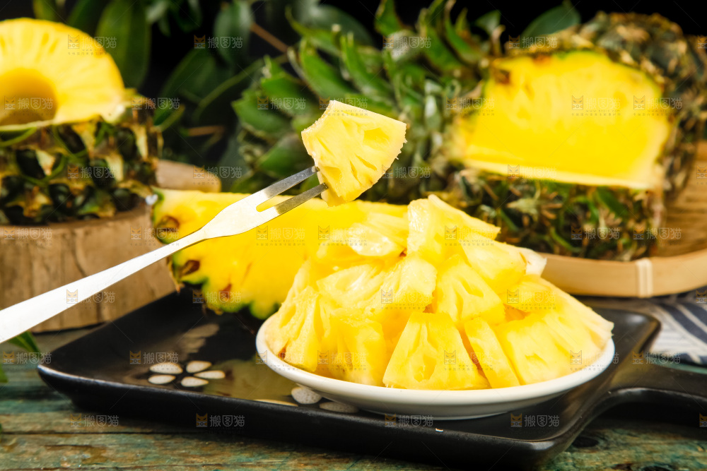 黑盘子上放着泰国小菠萝