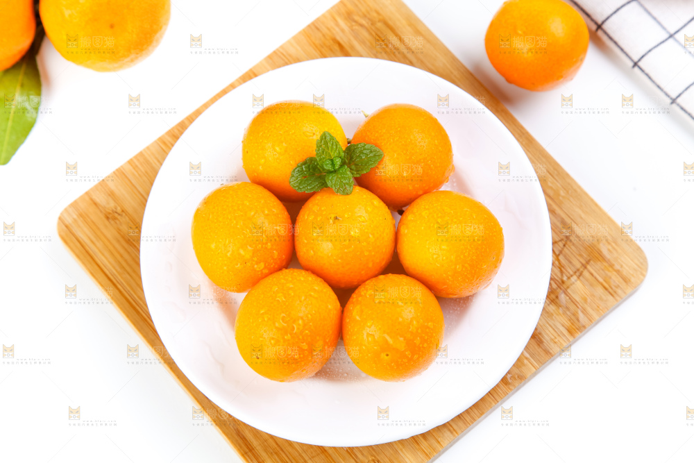 木板上放着一盘黄皮小金桔