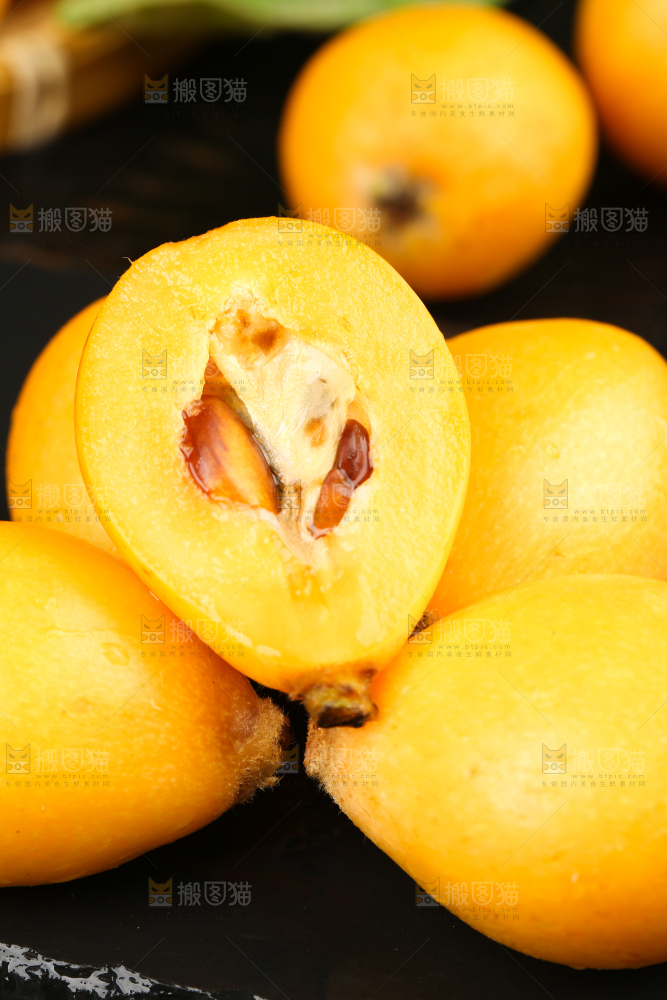 黑石板上放着米易枇杷