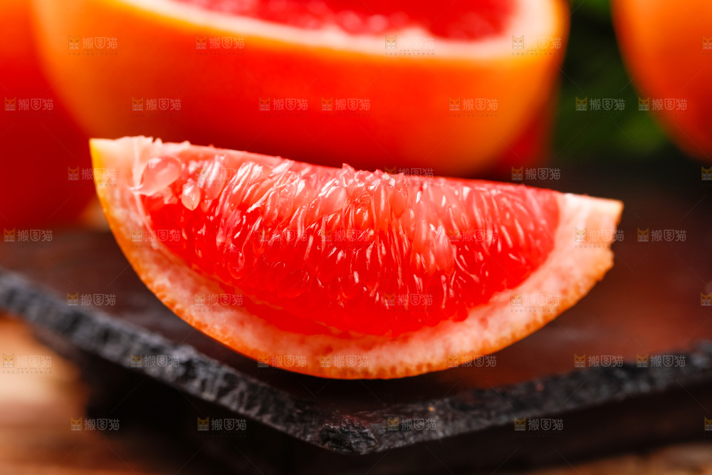 黑石板上放着红肉葡萄柚