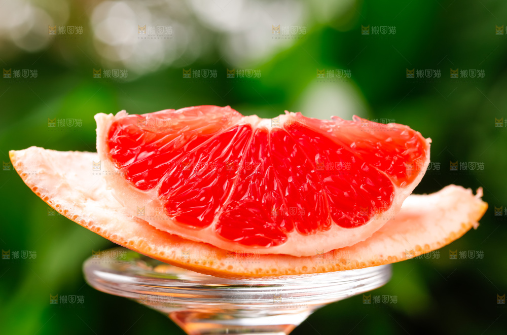 玻璃杯上放着红肉西柚
