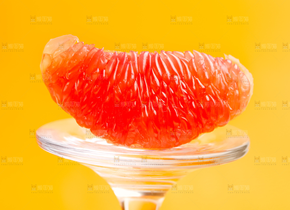 玻璃杯上放着红肉柚子