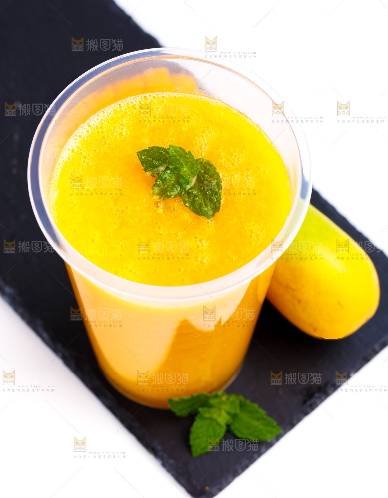黑石板上放着一杯芒果汁