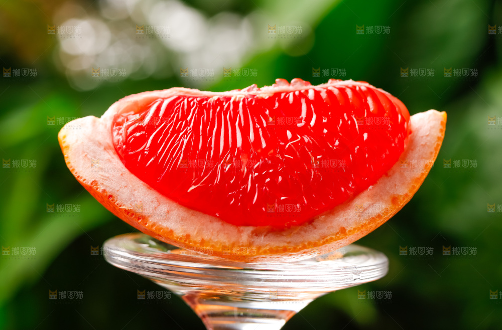 玻璃杯上放着红肉西柚