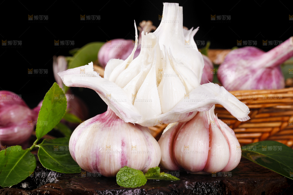 黑底上放着剥皮的新鲜紫皮大蒜