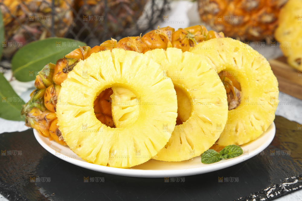 黑石板上放着一盘新鲜菠萝果肉