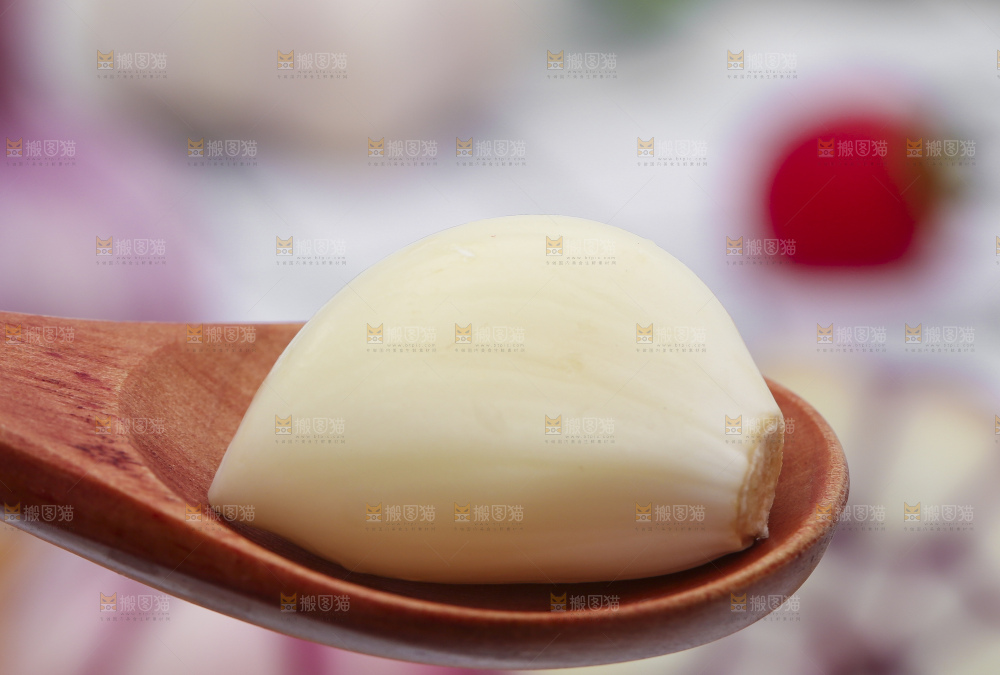 勺子里装着剥皮的大蒜头