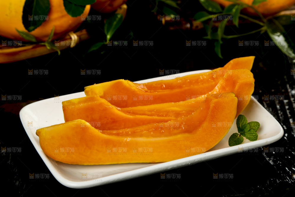 黑底上放着新鲜的海南红心木瓜