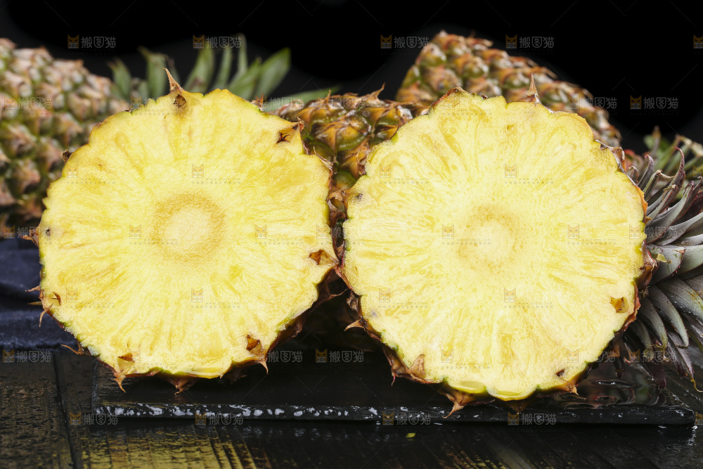 黑石板上放着切开的新鲜凤梨