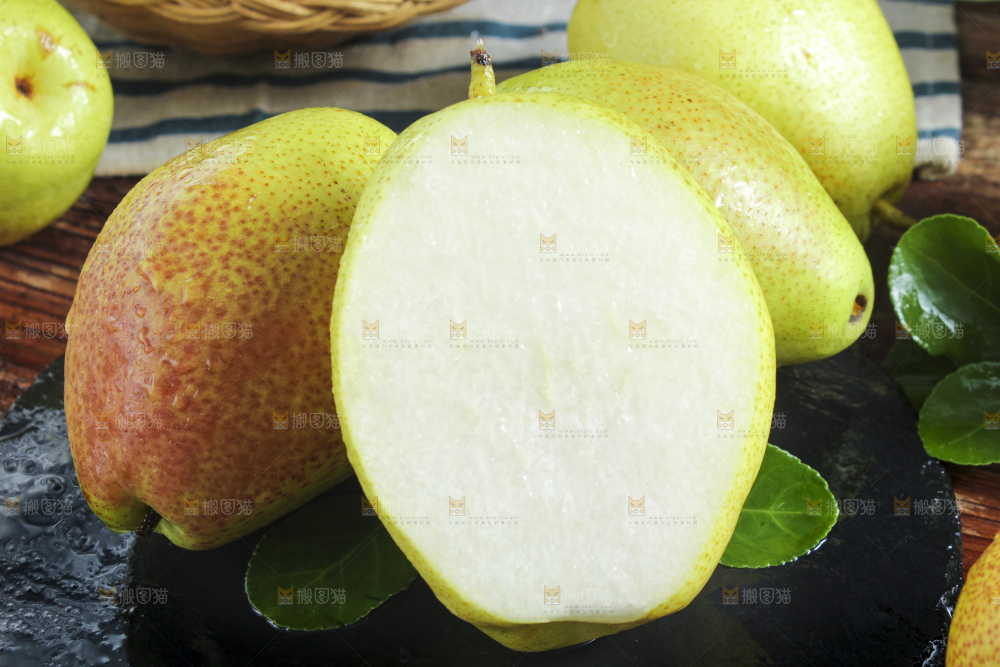 黑石板上放着切开的新鲜香梨