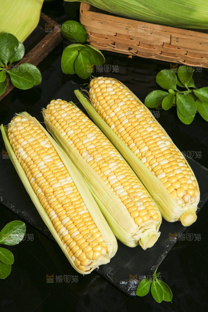 黑石板上放着剥皮的玉米