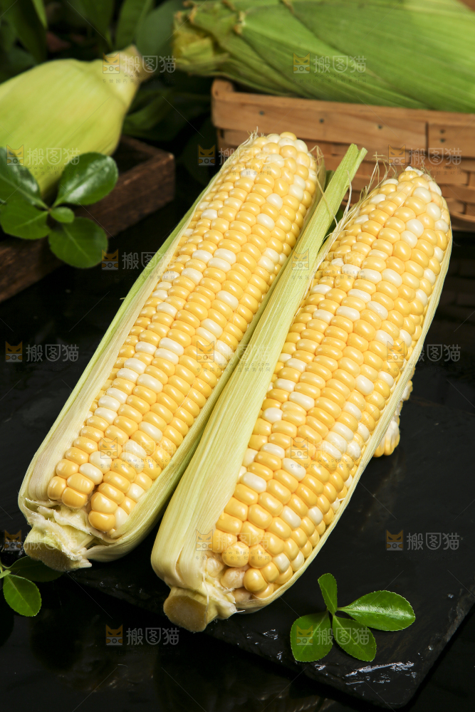 黑石板上放着剥皮的玉米