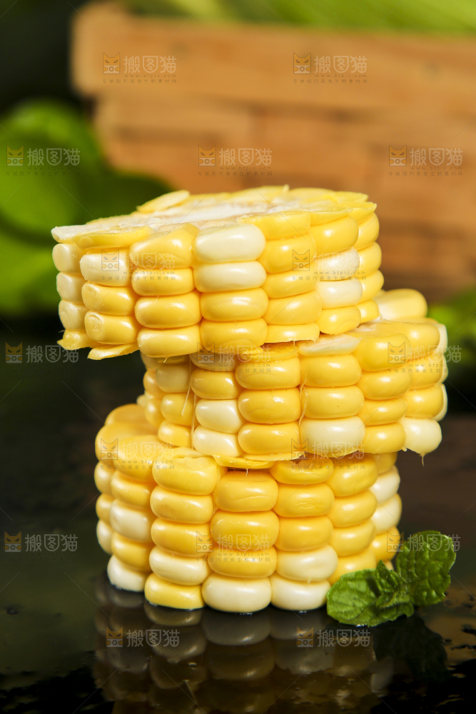 黑石板上放着切块的甜玉米