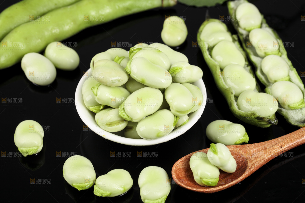 一碗新鲜蚕豆粒放在黑底上