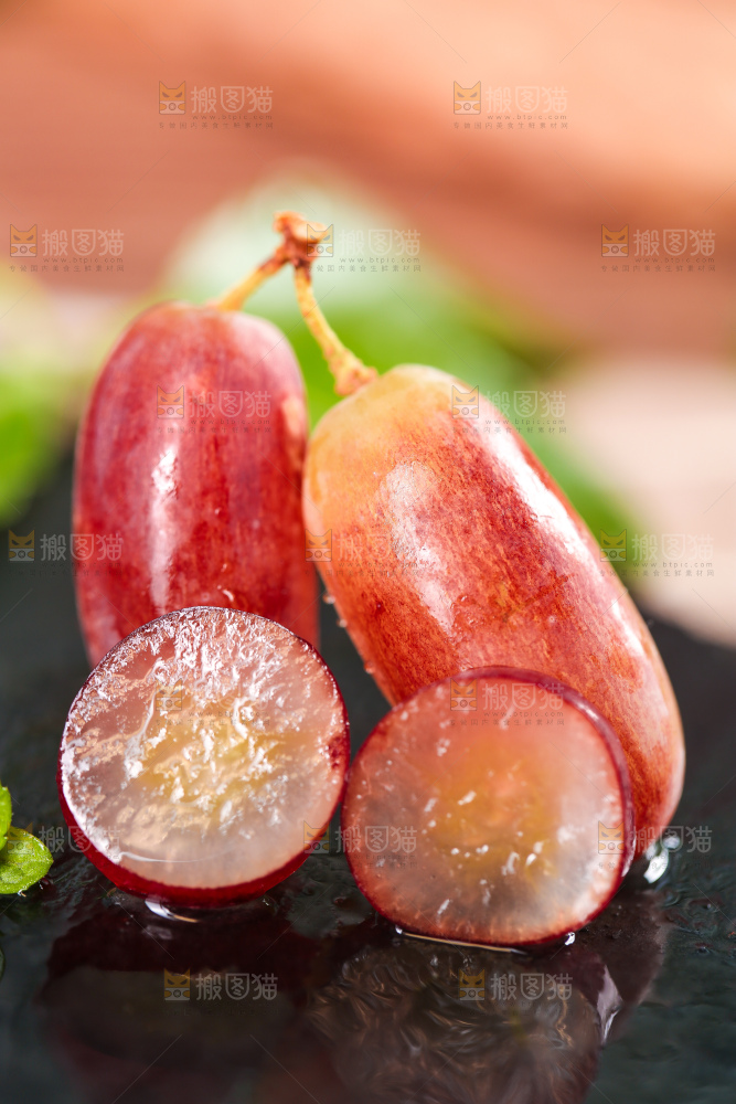 黑石板上放着切开的美人指葡萄