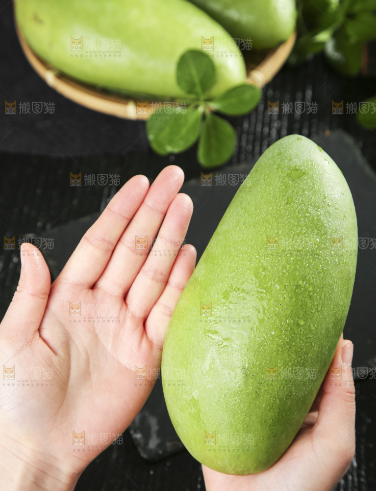 手拿着青皮芒果