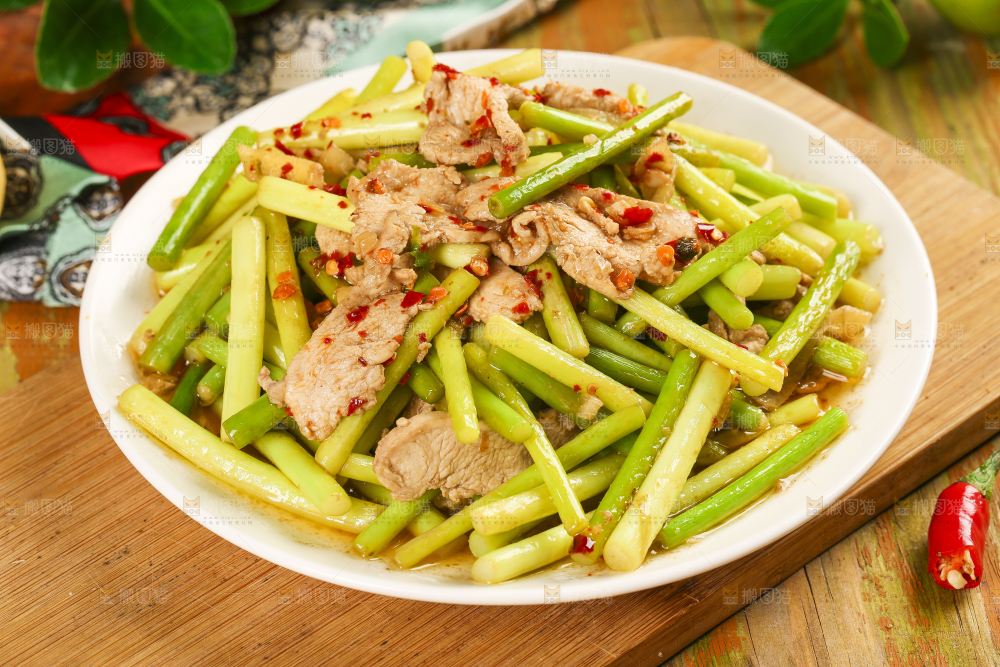 木板上放着一盘蒜苔炒肉