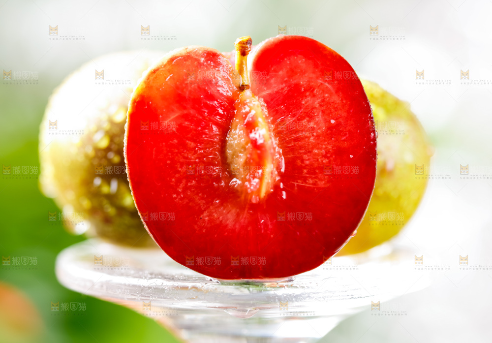 玻璃杯上放着红心李