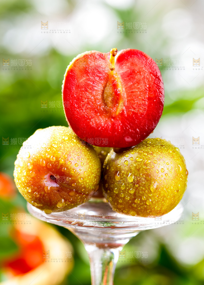 玻璃杯上放着红心李