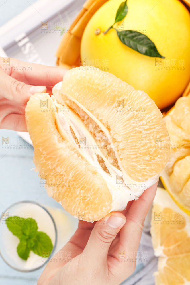手上拿着白心蜜柚