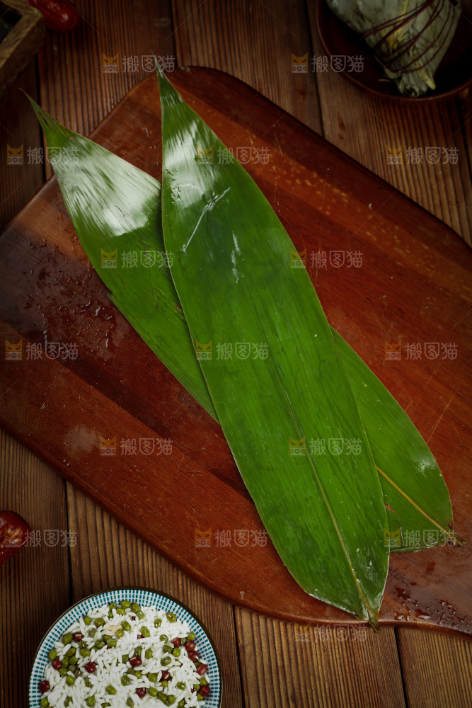 木板上放着大片粽叶