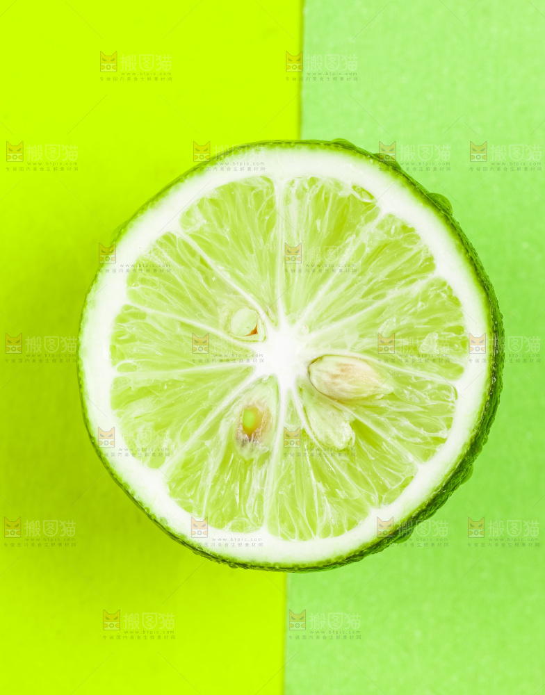 绿底上放着一个切半的青柠檬