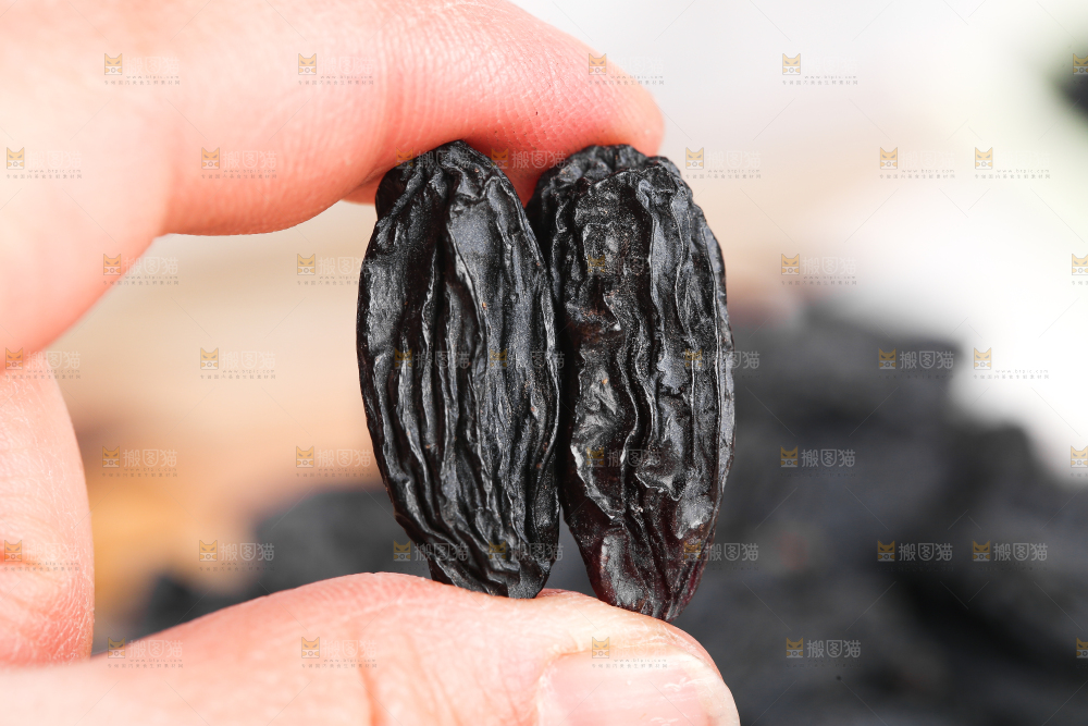 手里拿着黑葡萄干