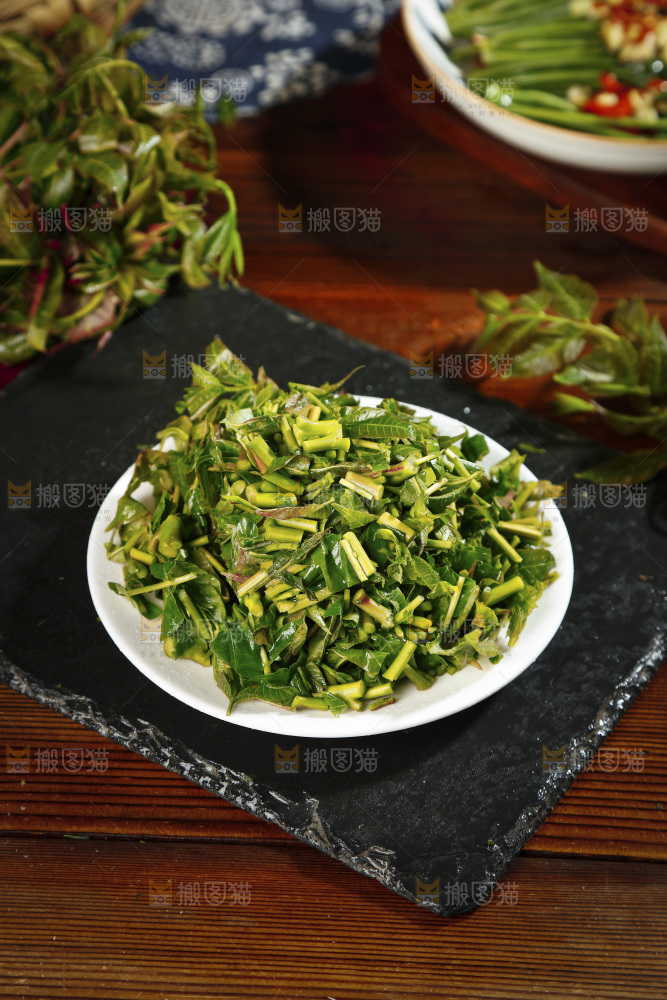 黑石板上摆放着一盘香椿