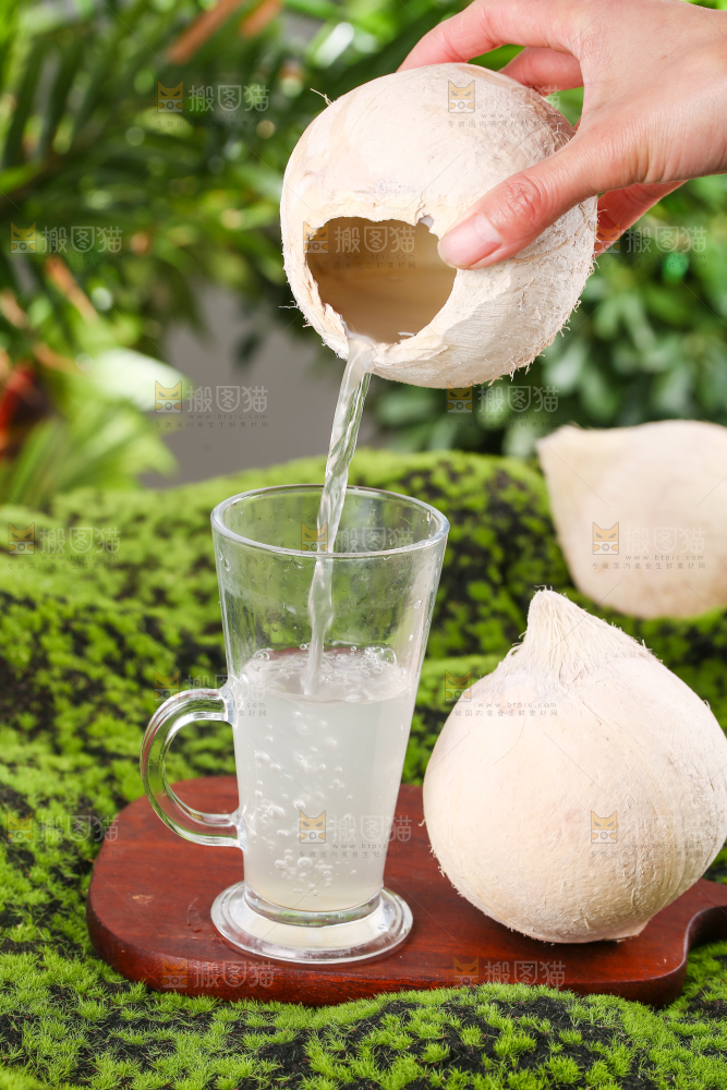 木板上放着椰子和一杯椰汁